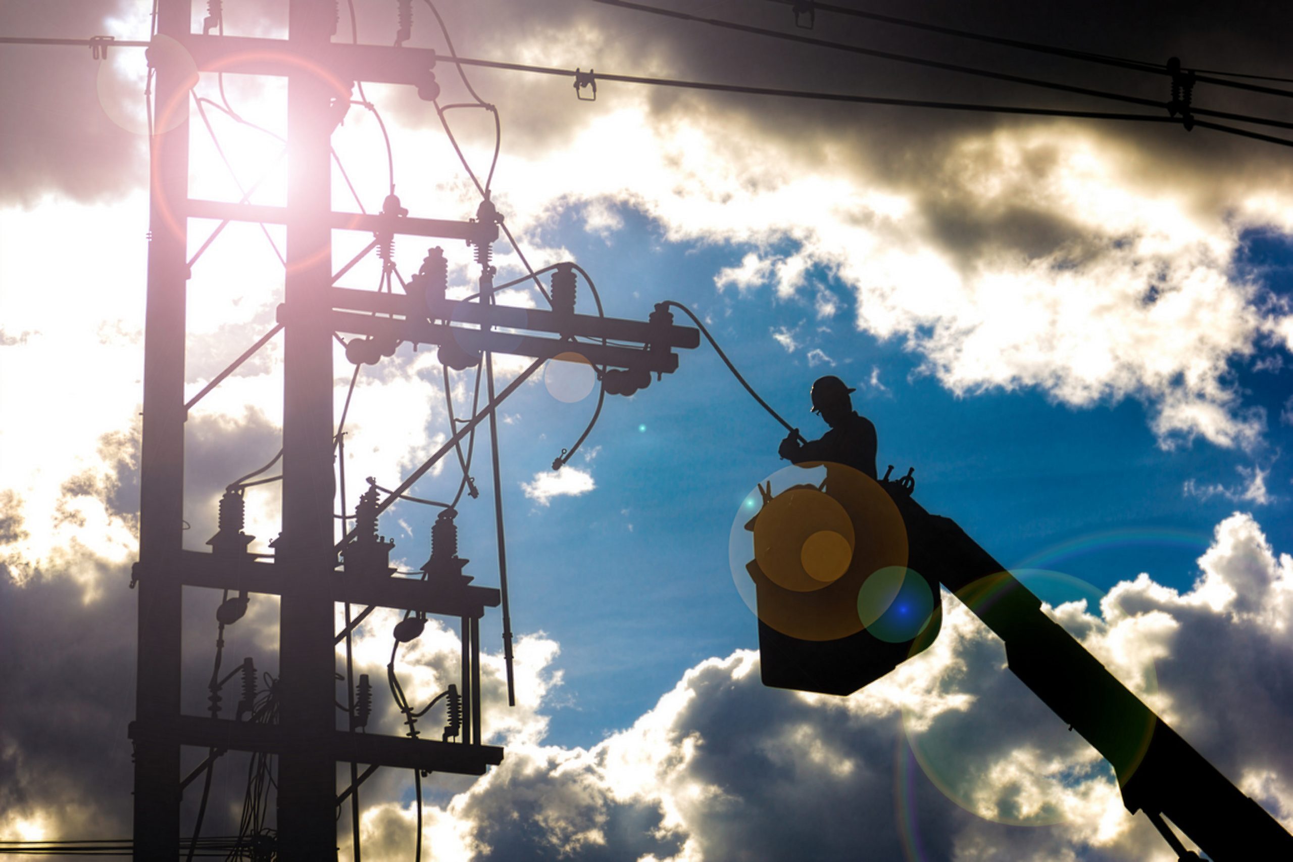 Utility lineworker in a bucket truck working on power lines