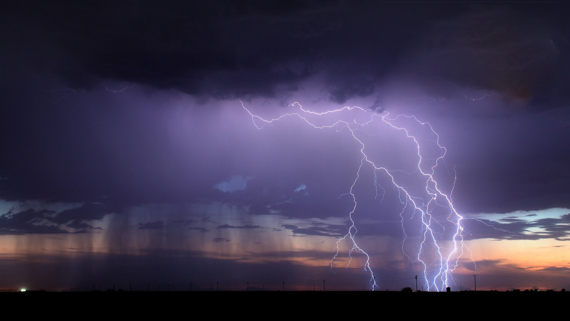 Lightning storm at night near utility lines