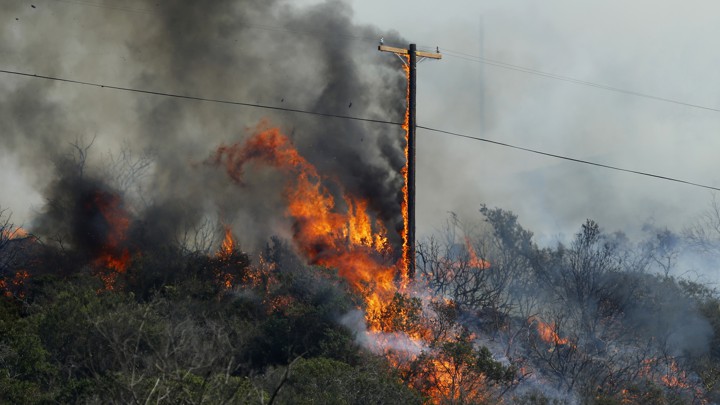 Wildfire burning near a utility pole
